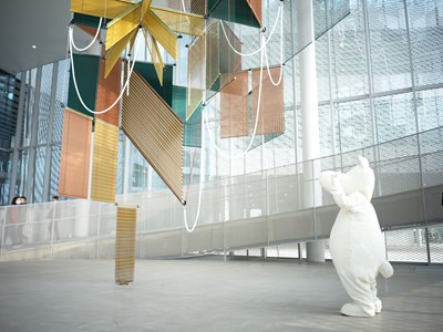 在挑高的美術館大廳空間中，大型藝術作品垂掛其間_0