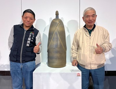Chun-Fu Shih, Deputy Director of the Cultural Affairs Bureau of Taichung City Government (left), and exhibiting artist  Tsai Jung-Yu (right) pose for a photo in front of the work “Family Affection”