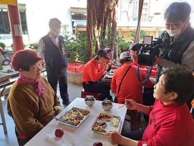 The production team filming elderly communal dining at a community care and support center