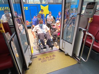 A bus driver sits in a wheelchair to experience getting on and off the bus for the physically challenged-adding more empathy from the actual operation.